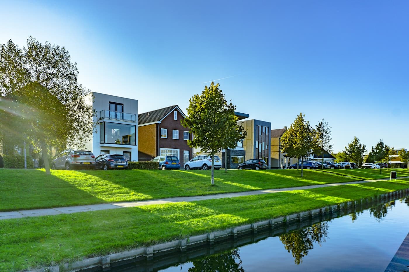 A row of modern residential home exteriors on a bright suburban street